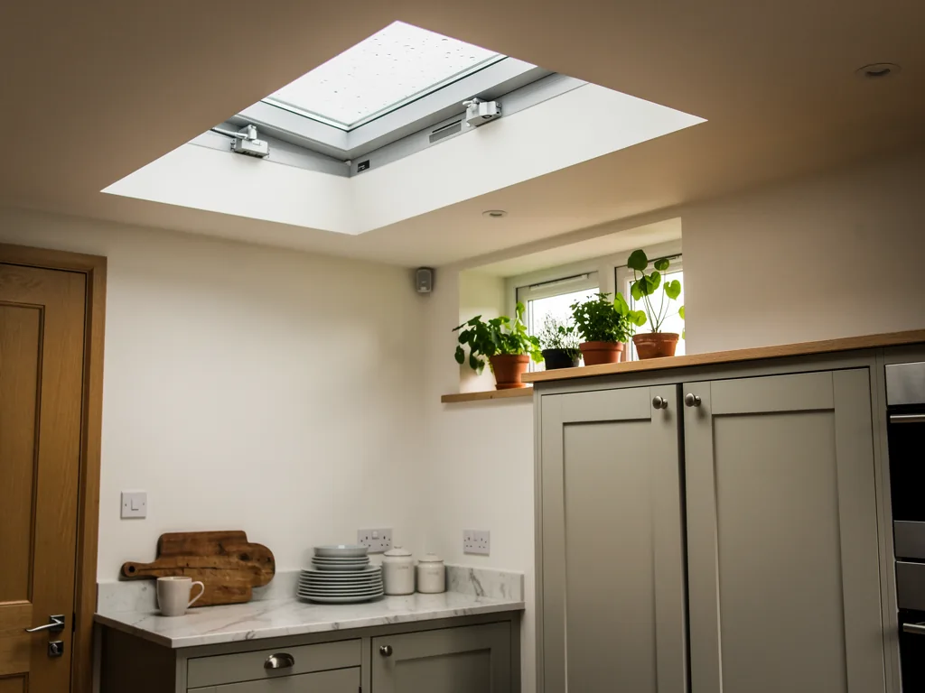 A flat rooflight in a kitchen ceiling opened for fresh air