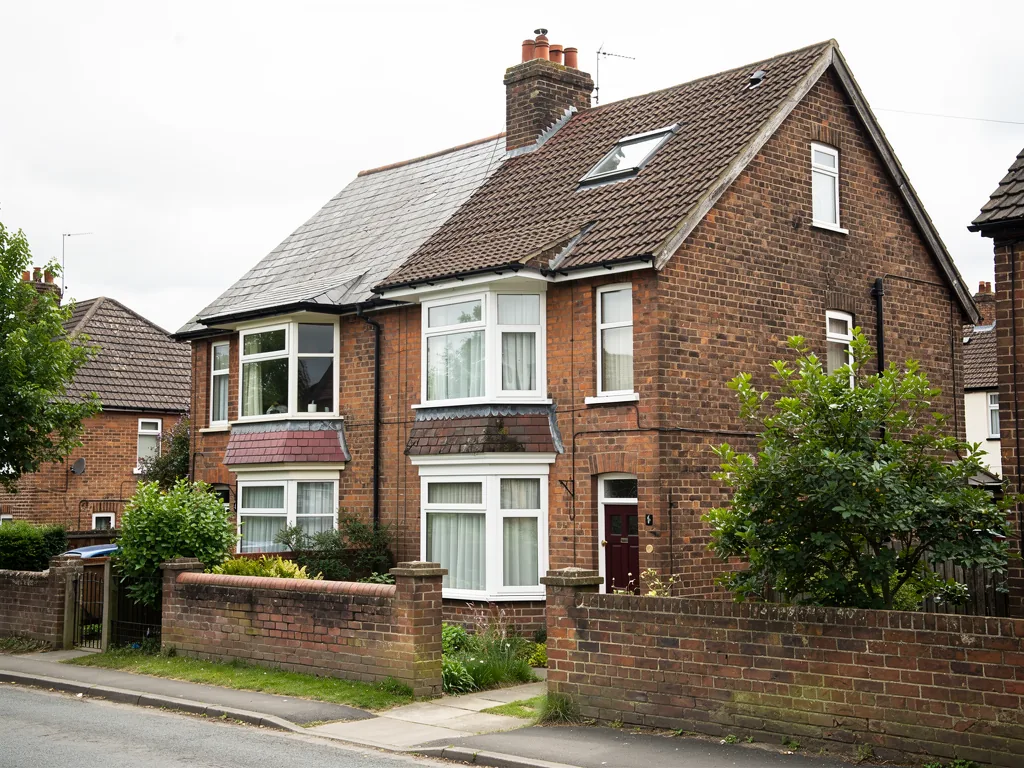A pair of 1930s semi-detached houses with hipped tiled roofs